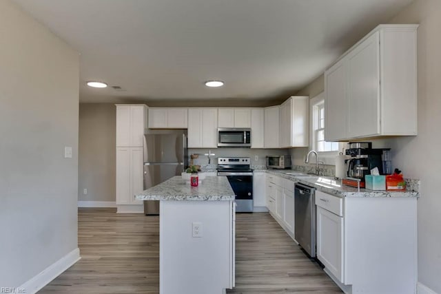 kitchen featuring a center island, stainless steel appliances, white cabinetry, and sink