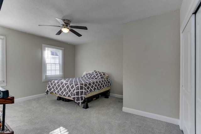 carpeted bedroom with ceiling fan and a closet