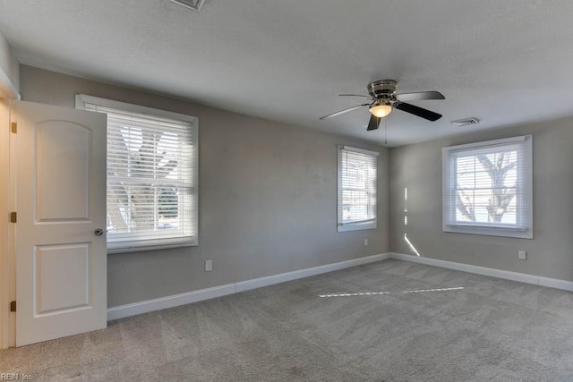 empty room featuring ceiling fan and light colored carpet