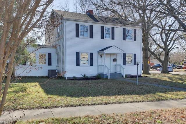 colonial home with central air condition unit and a front yard