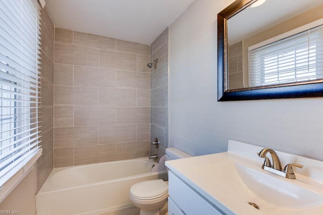 full bathroom featuring vanity, tiled shower / bath combo, and toilet