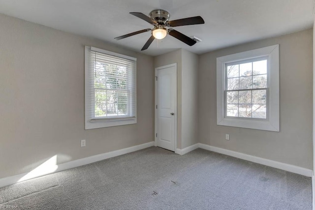 carpeted spare room with ceiling fan