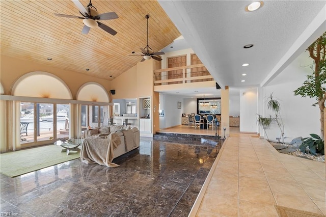 living room with ceiling fan, wooden ceiling, and a high ceiling