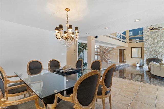 dining room with ceiling fan with notable chandelier and a fireplace