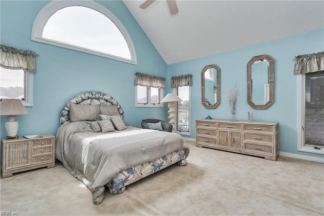 carpeted bedroom with ceiling fan and high vaulted ceiling