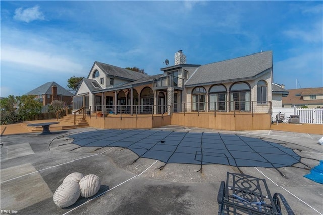 back of house featuring a patio area, a balcony, cooling unit, and a covered pool