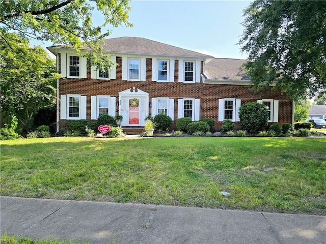 colonial-style house featuring a front lawn