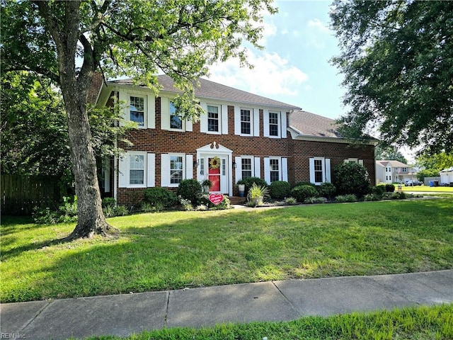 colonial-style house featuring a front yard