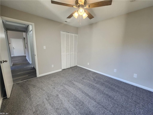 unfurnished bedroom with dark colored carpet, ceiling fan, and a closet