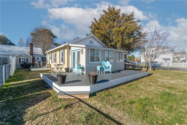 back of house featuring a lawn and a wooden deck