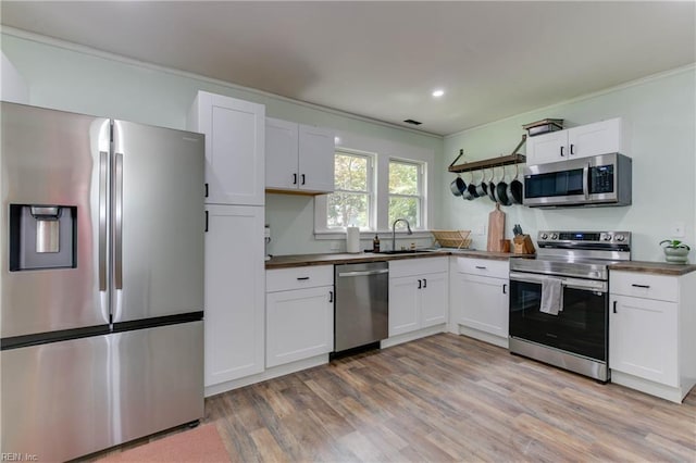 kitchen with white cabinetry, light hardwood / wood-style floors, and appliances with stainless steel finishes