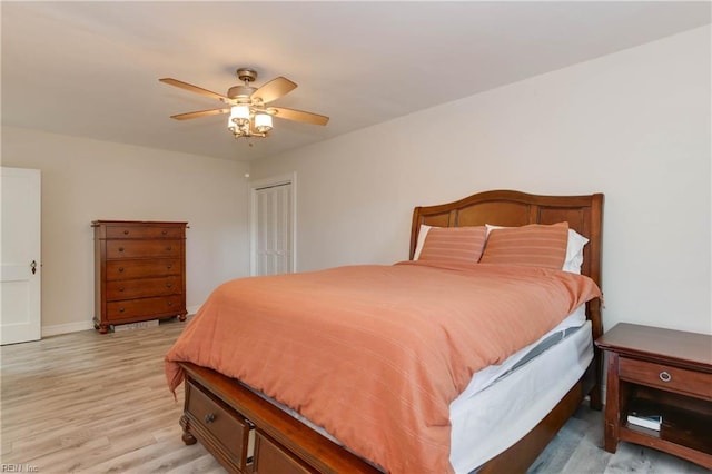 bedroom with ceiling fan, light wood-type flooring, and a closet