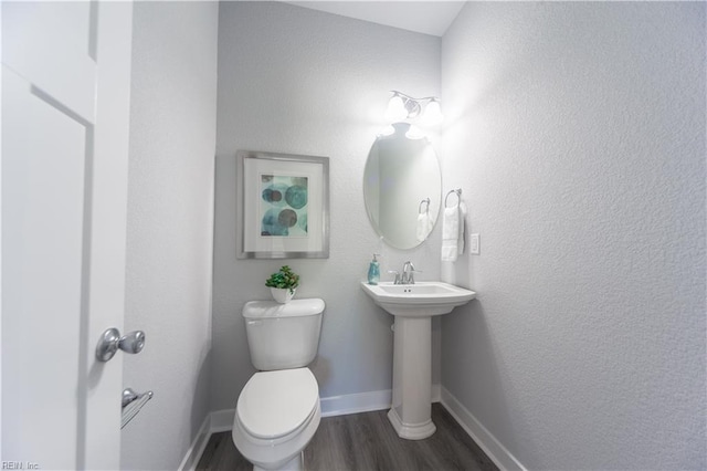 bathroom with hardwood / wood-style floors and toilet