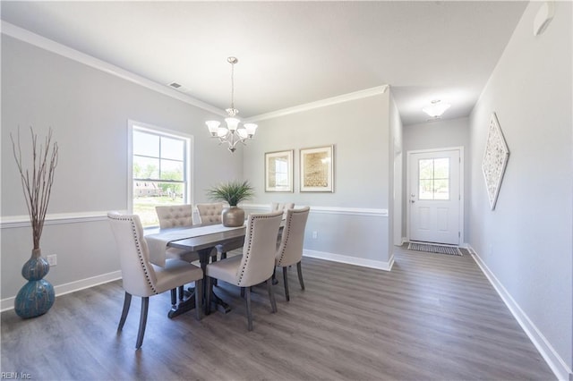 dining room featuring a notable chandelier, dark hardwood / wood-style floors, plenty of natural light, and crown molding