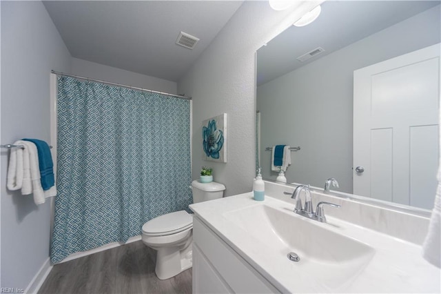 bathroom with hardwood / wood-style floors, vanity, curtained shower, and toilet