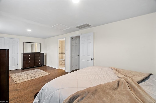 bedroom featuring dark hardwood / wood-style floors and ensuite bath