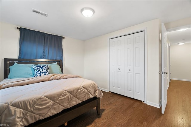 bedroom with dark hardwood / wood-style flooring and a closet