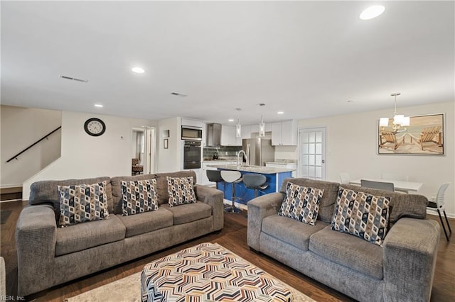 living room featuring dark hardwood / wood-style floors and an inviting chandelier