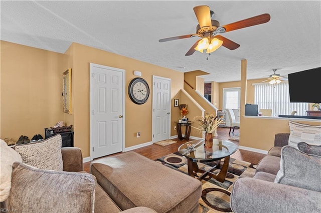 living room featuring ceiling fan, hardwood / wood-style floors, and a textured ceiling