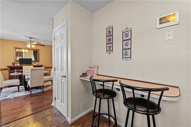 tiled dining area featuring ceiling fan and a textured ceiling