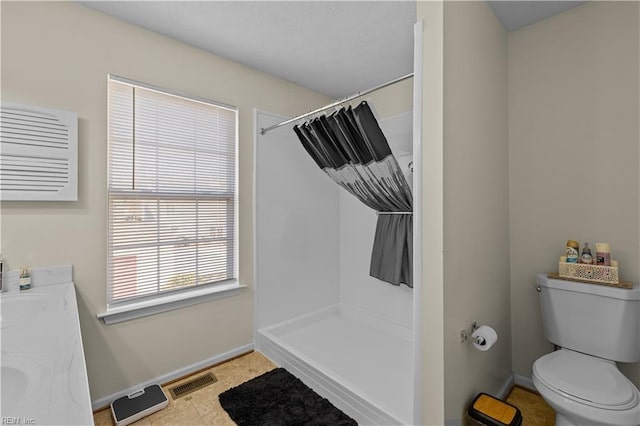 bathroom featuring vanity, curtained shower, and toilet