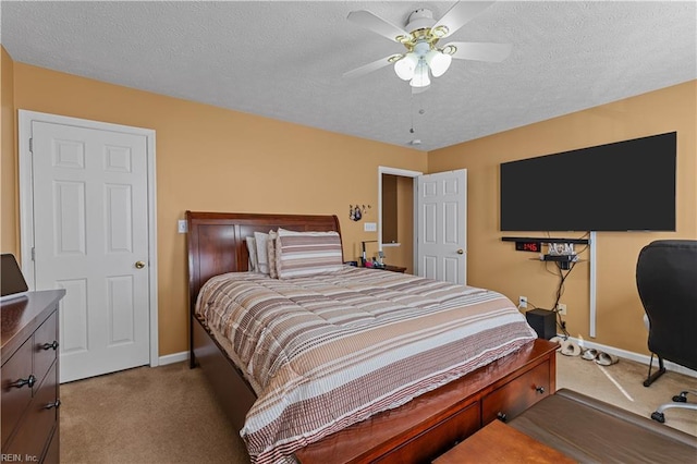 bedroom with a textured ceiling, light colored carpet, and ceiling fan