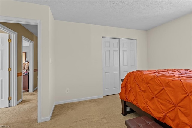 carpeted bedroom featuring a closet and a textured ceiling