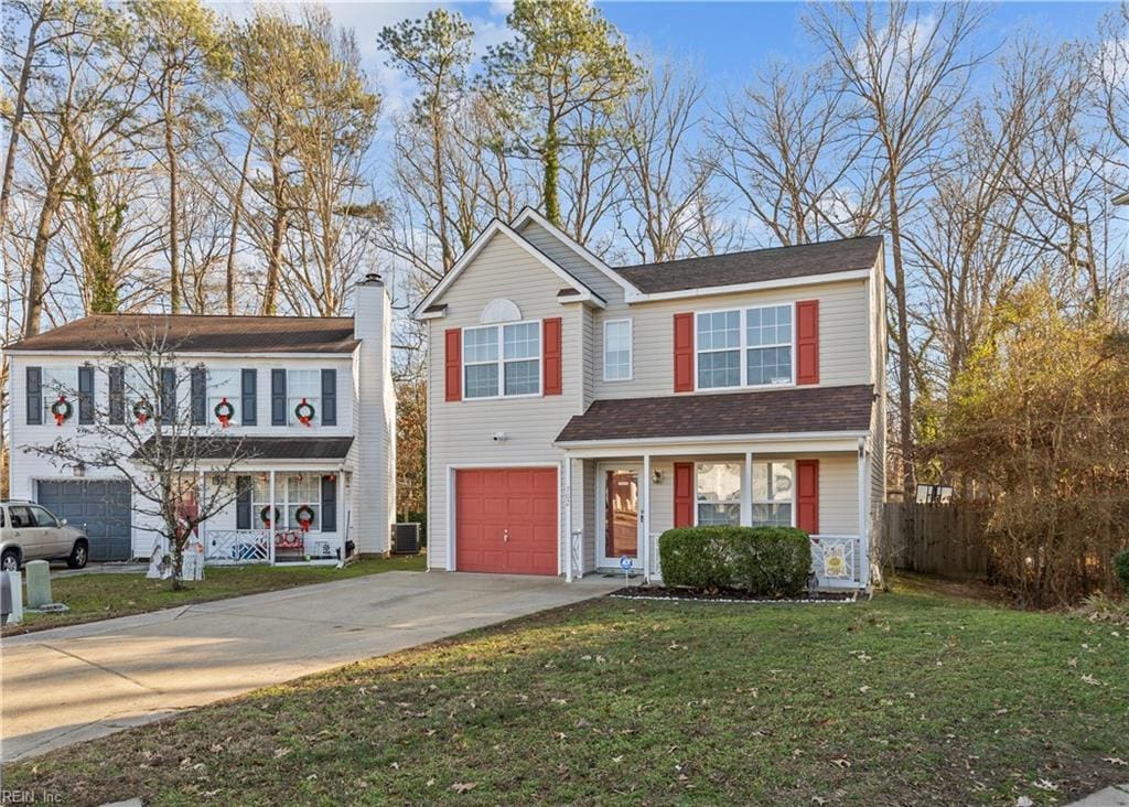 view of front of house with a porch, a garage, central air condition unit, and a front yard