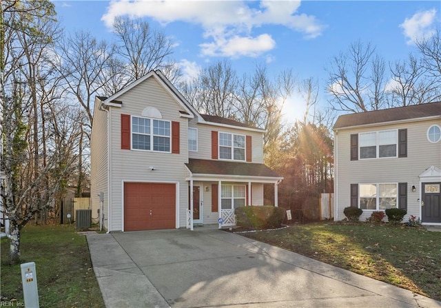 view of property with a garage, central air condition unit, and a front lawn