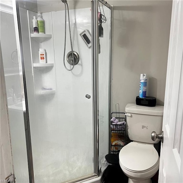 bathroom featuring toilet and an enclosed shower