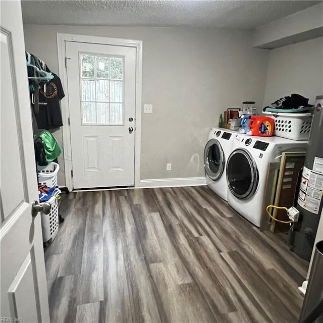 washroom featuring gas water heater, washing machine and dryer, dark hardwood / wood-style flooring, and a textured ceiling