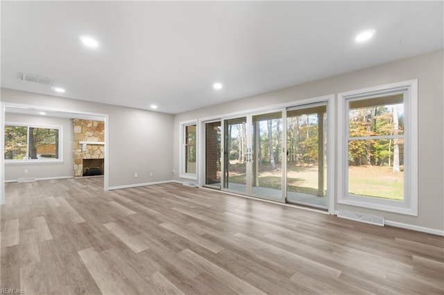 unfurnished living room with a fireplace and light hardwood / wood-style flooring