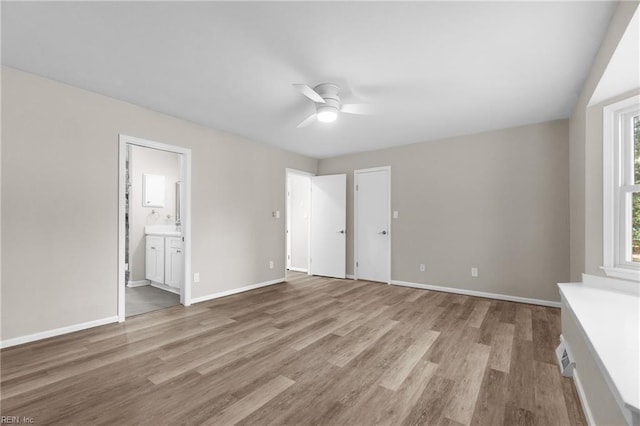 interior space with ceiling fan, light hardwood / wood-style flooring, and ensuite bath