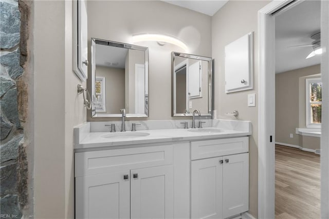 bathroom with wood-type flooring, vanity, and ceiling fan