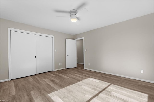 unfurnished bedroom with a closet, light hardwood / wood-style flooring, and ceiling fan