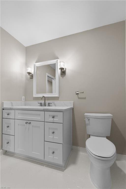 bathroom with tile patterned flooring, vanity, and toilet