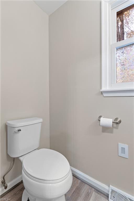 bathroom with hardwood / wood-style flooring and toilet