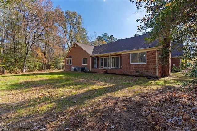 rear view of house featuring a yard and central air condition unit