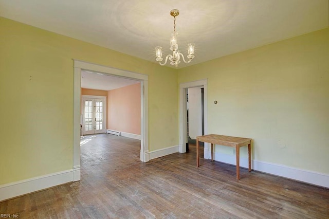 unfurnished dining area with a notable chandelier, a baseboard heating unit, wood-type flooring, and french doors