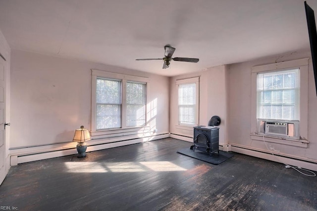 interior space featuring baseboard heating, a wood stove, plenty of natural light, and dark wood-type flooring