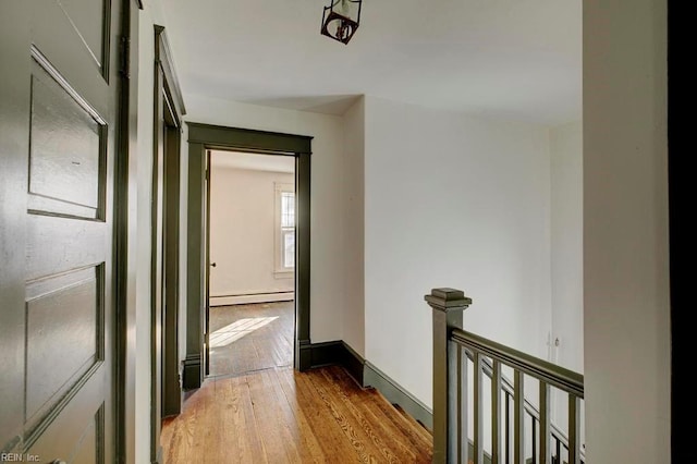 hall with hardwood / wood-style flooring and baseboard heating