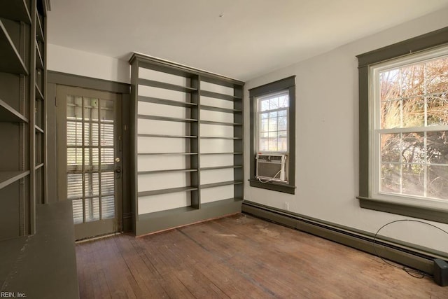 empty room with baseboard heating, cooling unit, and dark hardwood / wood-style floors