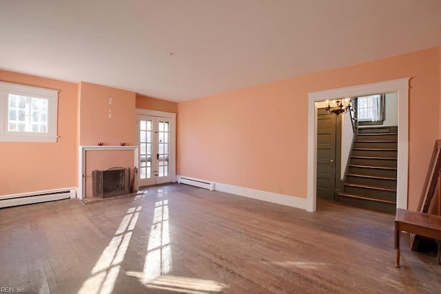 unfurnished living room with french doors, hardwood / wood-style flooring, and a baseboard heating unit