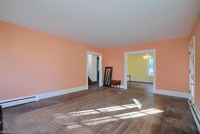 spare room featuring dark wood-type flooring, a notable chandelier, and a baseboard heating unit