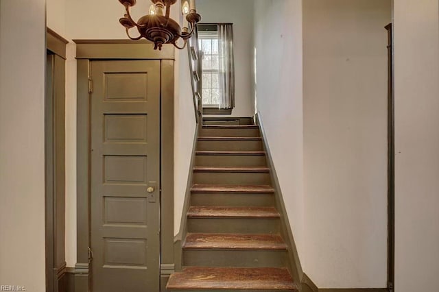 staircase featuring a notable chandelier