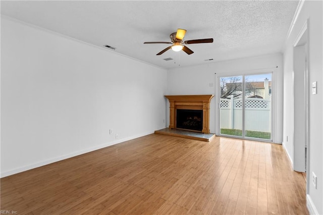 unfurnished living room featuring ceiling fan, a textured ceiling, and light hardwood / wood-style flooring