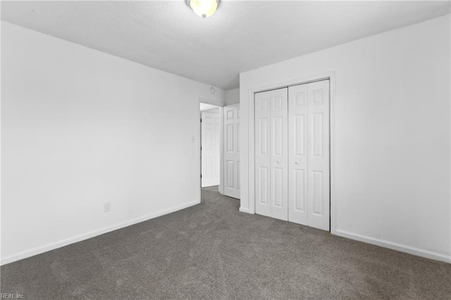 unfurnished bedroom featuring a closet and dark carpet