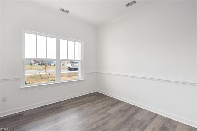 empty room featuring ornamental molding and dark wood-type flooring