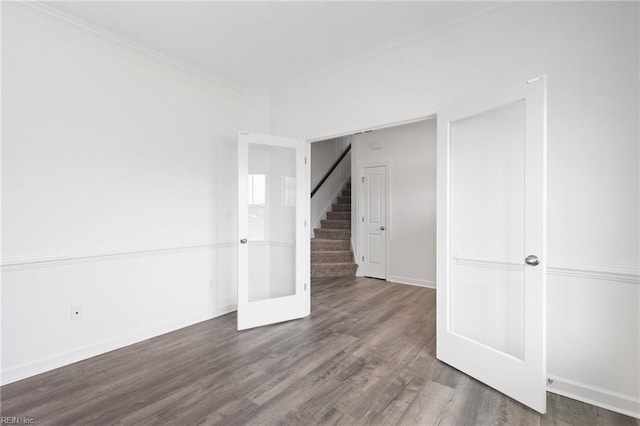 unfurnished room with ornamental molding and dark wood-type flooring