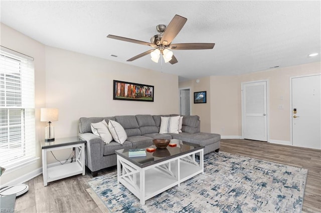 living room featuring wood-type flooring and ceiling fan